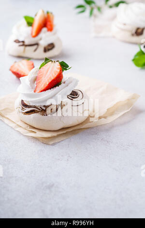 Pavlova meringuée gâteaux avec les baies fraîches sur fond clair. Banque D'Images