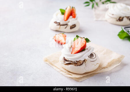 Pavlova galettes de fruits avec des fraises, du chocolat et de la menthe. Banque D'Images