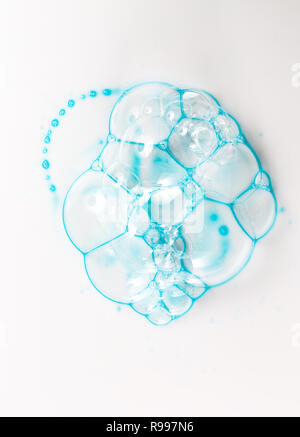 Des bulles de savon sur un fond blanc de blue gel douche, vue d'en haut. Banque D'Images