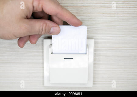 Insérer la main libre carte-clé pour ouvrir la lumière en électronique chambre d'hôtel. Chambre d'hôtel de carte clé dans serrure électronique sur le mur Banque D'Images