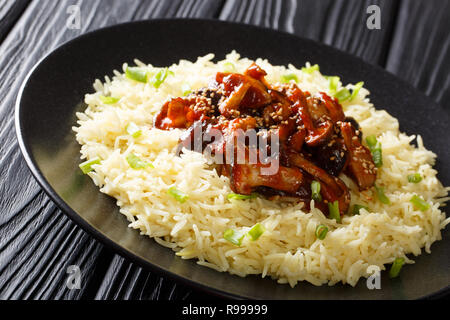 Champignons shiitake frais frit épicé avec des graines de sésame, accompagné de riz libre sur une plaque sur la table horizontale. Banque D'Images