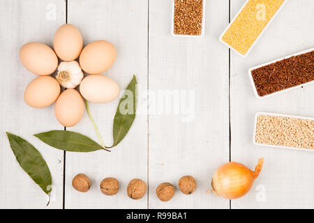 Divers dans des bols de gruau, les oeufs, la feuille de énoncés dans la forme d'une fleur sur table en bois blanc Banque D'Images