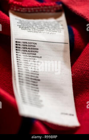 Étiquette à l'intérieur sur rouge chemise en coton. 100 % coton texte sur de nombreuses langues. Banque D'Images