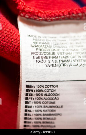 Étiquette à l'intérieur sur rouge chemise en coton. 100 % coton texte sur de nombreuses langues. Banque D'Images