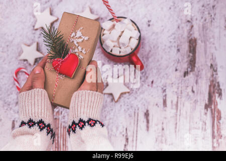 Femme hands holding a Christmas gift box. Des cadeaux de Noël et Nouvel An. Fait main. Vue supérieure avec copie espace - Image Banque D'Images