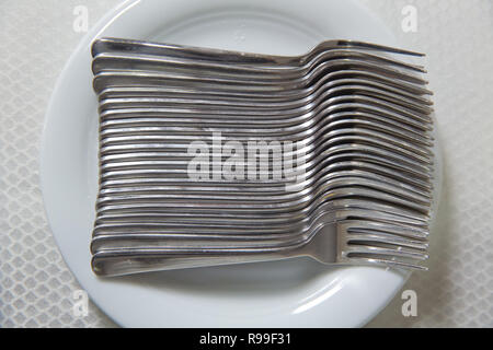 Plaque blanc vide, couverts, serviette sur fond gris. Les fourches sont en plaque blanche . Banque D'Images