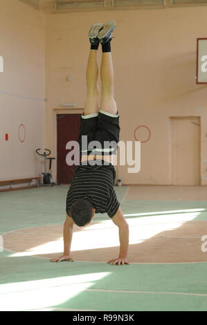Kovrov, la Russie. 13 octobre 2013. Teen doing handstand dans la salle de sport Banque D'Images