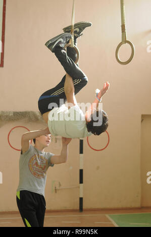 Kovrov, la Russie. 13 octobre 2013. L'adolescence est engagé sur les anneaux de gymnastique dans le gymnase de l'école Banque D'Images
