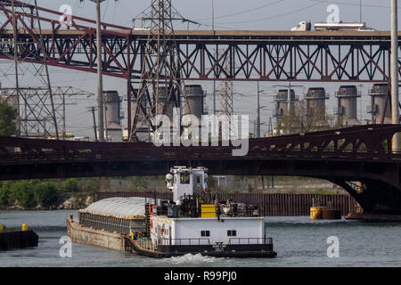 Barge et remorqueur de rivière Calumet avec la Chicago Skyway, 95th Street Bridge et du gaz naturel centrale dans la distance. Banque D'Images