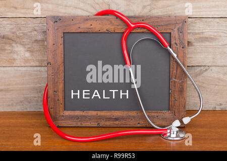 Concept de médecine - Tableau noir avec word "santé" et stéthoscope sur fond de bois Banque D'Images