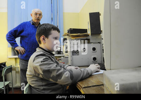 Kovrov, la Russie. 29 janvier 2014. Mentor section radio club pour enfants 'Atlas' regarder l'élève pendant les cours Banque D'Images