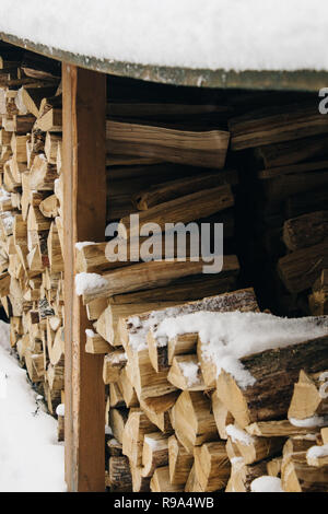 Bois de chauffage empilé sous un auvent, bois de chauffage pour l'hiver. Paysage d'hiver Banque D'Images