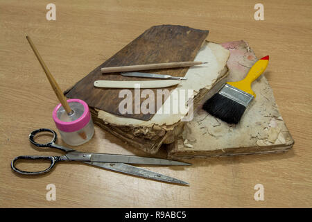 Laboratoire de restauration. Livres anciens entouré d'outils et d'équipement. Banque D'Images