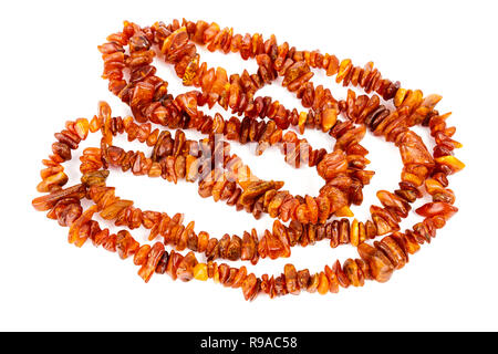 Chaîne de perles d'ambre baltique isolé sur fond blanc. Collier ambre orange vif de matières perles en un tas. Banque D'Images