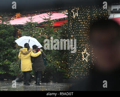 Cologne, Allemagne. 21 décembre 2018, Berlin, Cologne : visiteurs franchissent le marché de Noël à la cathédrale de parapluies entre les stands. Sur le 4ème week-end de l'Avent, la Rhénanie et la pluie attend des températures douces. Photo : Henning Kaiser/dpa dpa : Crédit photo alliance/Alamy Live News Banque D'Images