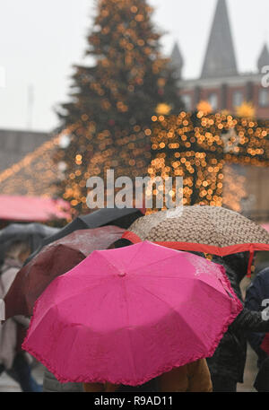 Cologne, Allemagne. 21 décembre 2018, Berlin, Cologne : visiteurs franchissent le marché de Noël à la cathédrale de parapluies entre les stands. Sur le 4ème week-end de l'Avent, la Rhénanie s'attend à ce que la pluie et des températures douces. Photo : Henning Kaiser/dpa dpa : Crédit photo alliance/Alamy Live News Banque D'Images