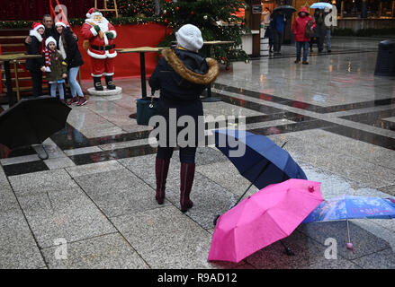 Cologne, Allemagne. 21 décembre 2018, Berlin, Cologne : les touristes ont quitté leurs parasols à la marché de Noël à la cathédrale pour prendre une photo avec un Santa doll. Sur le 4ème week-end de l'Avent, la Rhénanie s'attend à ce que la pluie et des températures douces. Photo : Henning Kaiser/dpa dpa : Crédit photo alliance/Alamy Live News Banque D'Images