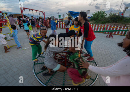 Palu, Central Sulawesi, Indonésie. 22 Décembre, 2018. Les enfants victimes du tremblement de jouer sur l'aire de jeux avec l'aide d'un organisme humanitaire international dans le camp de réfugiés d'Balaroa. Les installations et l'infrastructure dans les camps pour les victimes de catastrophes d'alléger le fardeau des résidents touchés par le séisme, le tsunami et la liquéfaction de Palu, Sigi et Donggala survenue le 28 septembre 2018. Credit : bmzIMAGES/Alamy Live News Banque D'Images