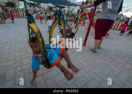 Palu, Central Sulawesi, Indonésie. 22 Décembre, 2018. Les enfants victimes du tremblement de jouer sur l'aire de jeux avec l'aide d'un organisme humanitaire international dans le camp de réfugiés d'Balaroa. Les installations et l'infrastructure dans les camps pour les victimes de catastrophes d'alléger le fardeau des résidents touchés par le séisme, le tsunami et la liquéfaction de Palu, Sigi et Donggala survenue le 28 septembre 2018. Credit : bmzIMAGES/Alamy Live News Banque D'Images