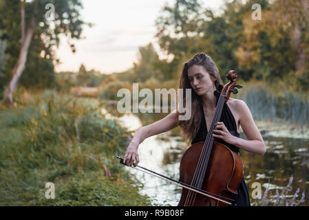 Le violoncelliste femelle joue dans le parc Banque D'Images