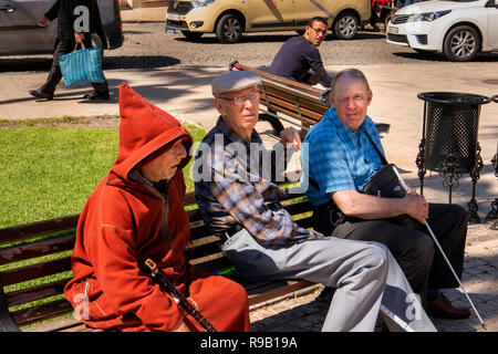 Maroc, Tanger, lieu 9 Avril, Grand Socco place publique, les touristes s'assit sur le banc à côté de l'homme en djellaba coat
