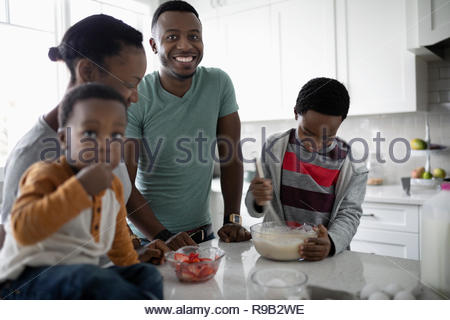 Portrait happy young family baking in kitchen