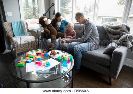 Les grands-parents et d'enfant en petite-fille using digital tablet sur salon canapé