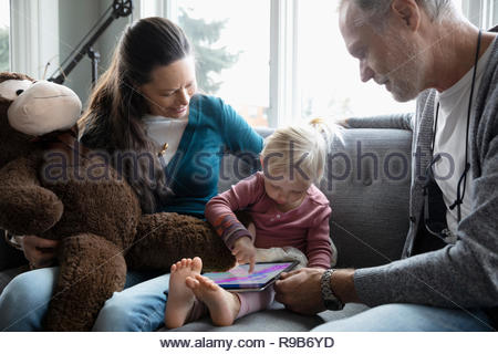 Les grands-parents en regardant sa petite-fille dessin sur tablette numérique