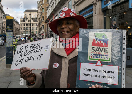 Une femme noire est tenant une pancarte du NHS enregistrer pendant la guerre contre mars fasciste en opposition à Tommy Robinson Brexit pro fasciste de mars à Londres, Dec 2018. Banque D'Images