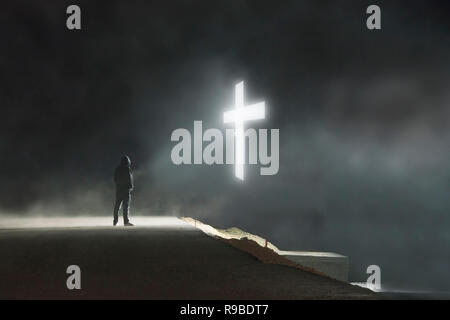 Un concept art numérique photo d'un lstanding figure à capuchon isolé sur une route à la croix à un flottant dans le ciel par une sombre nuit brumeuse Banque D'Images