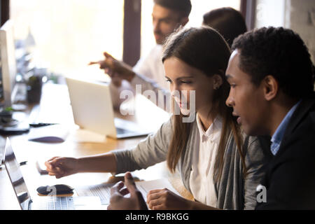 Millénaire divers employés qui travaillent ensemble à l'aide de l'ordinateur portable de Banque D'Images