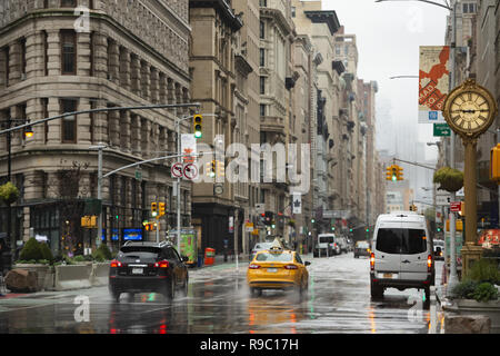 Les voitures et les taxis relient la 5e avenue sur un jour froid et pluvieux. Manhattan, New York City, United States. Banque D'Images