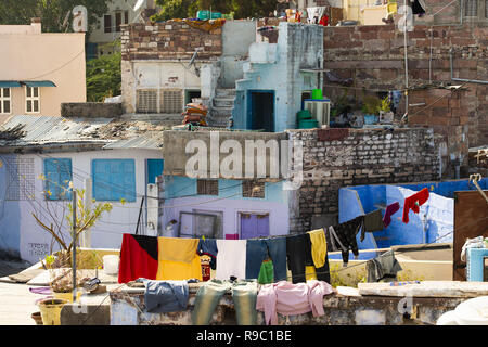 Vue rapprochée de certains toits avec des vêtements en train de sécher dehors dans la ville bleue de Jodhpur, Inde. Banque D'Images