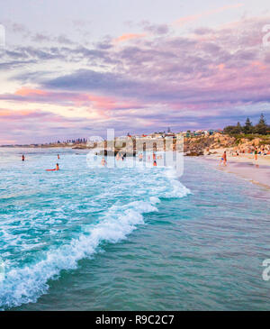 Les gens dans la mer à Trigg Beach sur une chaude soirée d'été. Perth, Australie occidentale Banque D'Images