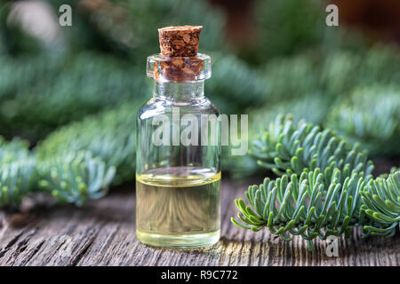 Une bouteille d'huile essentielle avec des branches de sapin Banque D'Images