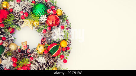 Vue supérieure de la couronne de Noël lumineux traditionnel décoré de pommes de pin, branches d'épinette, de baies, de boules, étoiles, bières décoratifs sur fond blanc est Banque D'Images