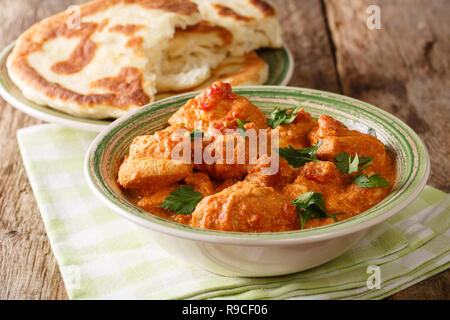 Karhai traditionnelle indienne recette de poulet en sauce tomate épaisse close up et naan sur la table horizontale. Banque D'Images