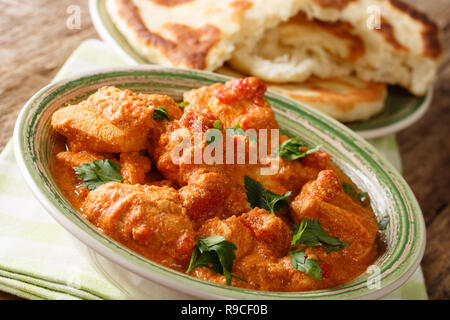 Poulet épicé indien traditionnel karhai close-up et de pain naan frais sur la table horizontale, style rustique. Banque D'Images