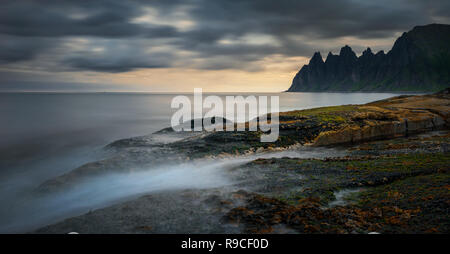 Panorama de l'Tugeneset côte rocheuse avec des montagnes en arrière-plan au coucher du soleil, Senja, Norvège Banque D'Images