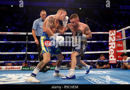 Josh Warrington (à gauche) et Carl Frampton en action dans le monde championnat poids plume à la Manchester Arena. Banque D'Images