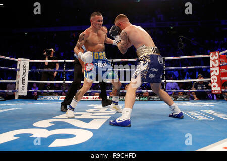 Josh Warrington (à gauche) et Carl Frampton en action dans le monde championnat poids plume à la Manchester Arena. Banque D'Images