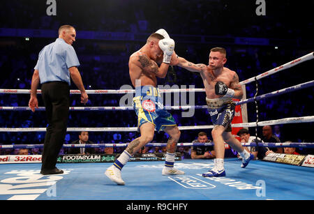 Josh Warrington (à gauche) et Carl Frampton en action dans le monde championnat poids plume à la Manchester Arena. Banque D'Images