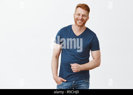 Hé charmante, quel est votre numéro. Portrait de beau mâle roux masculin en bleu t-shirt, gesticulant et sourire tout en ayant la conversation et profiter de passer du temps avec des amis Banque D'Images