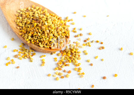 Bee pollen dans la cuillère sur fond blanc. Matières premières biologiques sains végétariens régime ingrédient alimentaire - Bee pollen. Banque D'Images