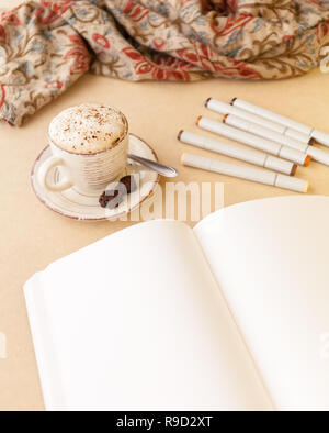 Ouvrez Carnet de croquis, tas de marqueurs artistique et Latte sur une table. Portrait Banque D'Images