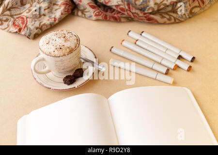 Ouvrez Carnet de croquis, tas de marqueurs artistique et Latte sur une table. Présentation Paysage Banque D'Images