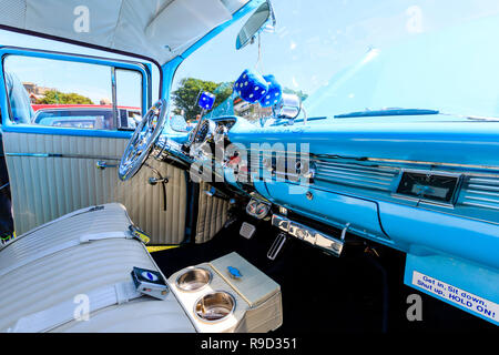 1957 Chevrolet Bel Air voiture. Par l'intérieur siège passager avant, fluffy dice suspendu à miroir, planche de bord bleu clair, signe, le ciel est un 57'. Banque D'Images