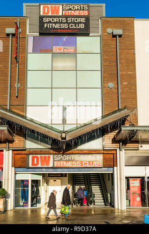 Centre commercial Westwood Cross, Broadstairs. DW magasin de sport et fitness club entrée avec un vieux couple passé. Banque D'Images