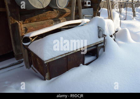 Kovrov, la Russie. 23 janvier 2016. Table de travail avec un vice de neige en face de l'ancienne grange dans la cour d'une maison en bois de plain pied Banque D'Images