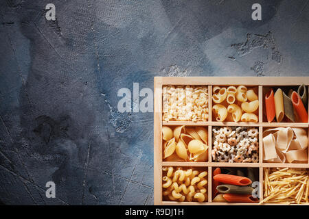 Diverses pâtes dans une boîte en bois avec copie espace, vue du dessus Banque D'Images